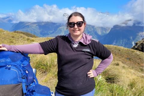 Beth Duffill-Brookes on a hike with a mountainous backdrop