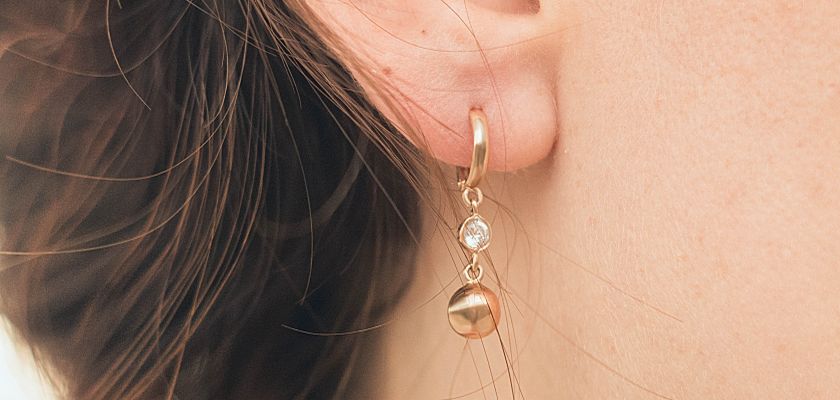 A close-up of an earring in a woman's ear