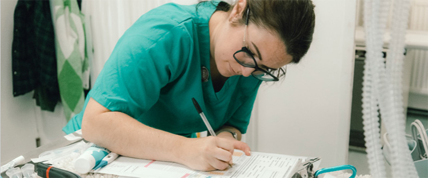 Veterinary nurse writing on a clipboard